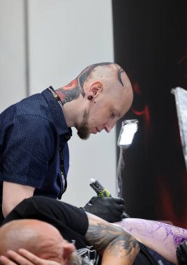 Krakow, Polonya - 11 Haziran 2022: 15 Krakow Dövme Festivali. En prestijli dövme festivallerinden biri. Dövmeci iş başında. Dövme işlemi..