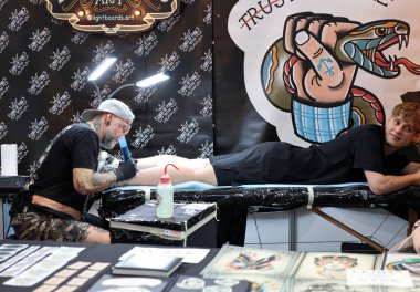 Krakow, Polonya - 11 Haziran 2022: 15 Krakow Dövme Festivali. En prestijli dövme festivallerinden biri. Dövmeci iş başında. Dövme işlemi..