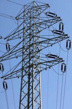 high voltage power pole and lines against the blue sky