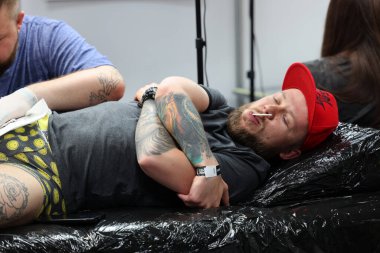 Krakow, Poland -  June 11, 2022: Unidentified  participant at 15th Tattoofest Convention in Cracow. One of the most prestigious tattoo festivals. Tattoo artist at work. 