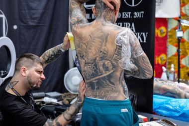 Krakow, Poland -  June 11, 2022: Unidentified  participant at 15th Tattoofest Convention in Cracow. One of the most prestigious tattoo festivals. Tattoo artist at work. 