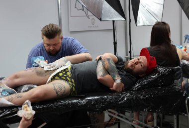 Krakow, Poland -  June 11, 2022: Unidentified  participant at 15th Tattoofest Convention in Cracow. One of the most prestigious tattoo festivals. Tattoo artist at work. 