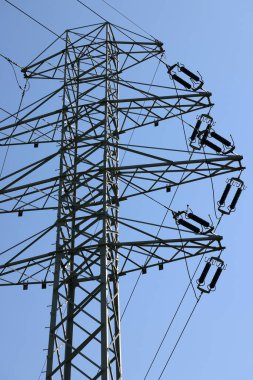 high voltage power pole and lines against the blue sky