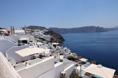 Oia, Santorini, Yunanistan - 3 Temmuz 2021: Yunanistan 'ın Santorini adasındaki Oia' da teras ve havuzlu ve güzel manzaralı bembeyaz evler 