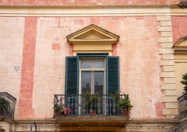 Facade of the house with shutters and small balcony in Matera. Basilicata, Italy