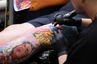 Krakow, Poland -  June 11, 2022: Unidentified  participant at 15th Tattoofest Convention in Cracow. One of the most prestigious tattoo festivals. Tattoo artist at work. 