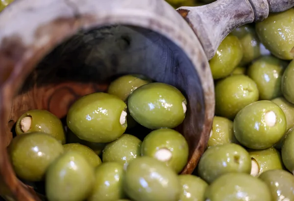 Stuffed green olives in an old wooden bowl