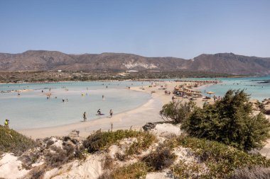 Elafonisi, Girit, Yunanistan - 19 Eylül 2021: Girit, Akdeniz 'deki Elafonisi' nin ünlü pembe mercan plajında dinlenen insanlar 