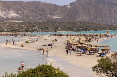 Elafonisi, Girit, Yunanistan - 19 Eylül 2021: Girit, Akdeniz 'deki Elafonisi' nin ünlü pembe mercan plajında dinlenen insanlar 