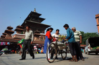 Kathmandu, Nepal - 19 Haziran 2019: Bisikletli meyve satıcısı Durbar Meydanı yakınlarındaki Katmandu Caddesi 'ndeki yerel halka mango satıyor