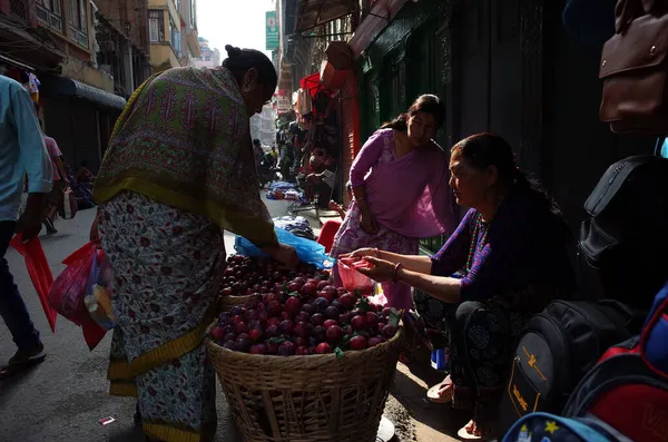 ネパール カトマンズ2019年6月17日 旧市街の狭い通りにある大きな籠から梅を売るネパール人女性 — ストック写真