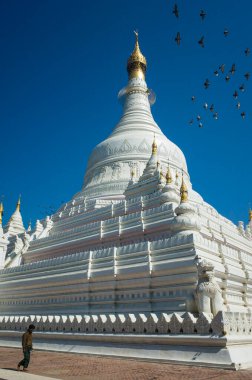 Amarapura, Mandalay, Myanmar - 14 Ocak 2020: Beyaz Pahtodawyi pagoda açık mavi gökyüzü altında, insanlar yürüyor ve güvercinler uçuşuyor