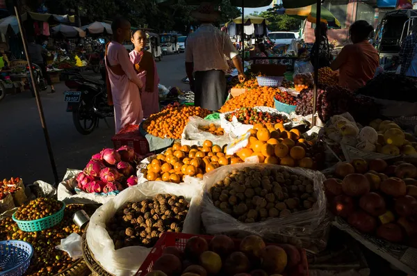 ミャンマーのマンダレー 2020年1月15日 チョ市場 オレンジのみかんに輝く太陽の光で果物の屋台の近くの仏教の修道女 ストリートフォト — ストック写真