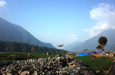 Lukla, Nepal - 8 Mayıs 2019: Himalayalar 'daki Tenzing Hillary Havaalanı' nın yanındaki kaldırımda yürüyen Nepal işçileri