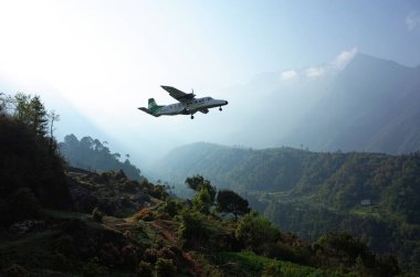 Lukla, Nepal - 8 Mayıs 2019: Himalayalar 'daki Tenzing Hillary Havaalanı' nın yanındaki kaldırımda yürüyen Nepal işçileri