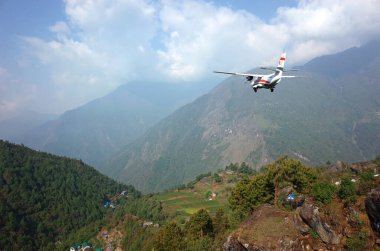 Lukla, Nepal - 8 Mayıs 2019: Himalayalar 'daki Tenzing Hillary Havaalanı' nın yanındaki kaldırımda yürüyen Nepal işçileri