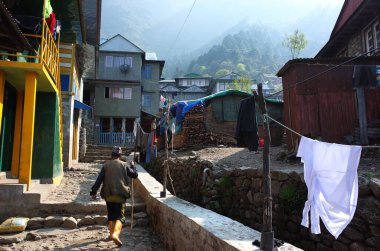 Lukla, Nepal - 8 Mayıs 2019: Himalayalar 'daki Lukla köyündeki kauçuk çizmeli Nepalli adam