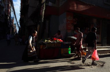 Katmandu, Nepal - 20 Haziran 2019: Geleneksel Tibet elbisesi içinde yaşlı bir kadının üzerinde güneş parıldıyor.