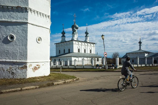 苏斯达尔街 俄罗斯传统建筑 俄罗斯金戒指四月中旬 在阳光灿烂的大道上 骑自行车的女人坐在彼得和保罗教堂旁边 — 图库照片