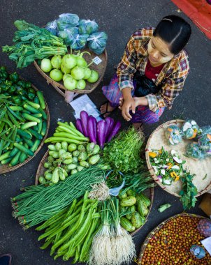 Yangon, Myanmar - 27 Aralık 2019: Sabah pazarında taze sebze satan kadın, sokak fotoğrafçılığı
