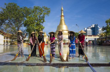 Yangon, Myanmar - 22 Aralık 2019: Geleneksel Burmalı kızlar Botataung Pagoda 'nın önündeki meydanı süpürge ve suyla temizliyor