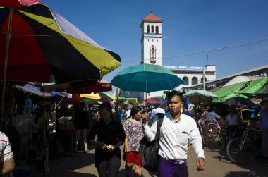Yangon, Myanmar - 22 Aralık 2019: Sıcak güneşli bir günde şemsiye altında yürüyen adam