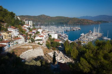 Fethiye, Türkiye - 28 Eylül 2019: Turkuaz su ve dağlarla Fethiye limanının manzarası, Antik Tiyatro Harabeleri önplanda Fethiye Antik Tiyatrosu