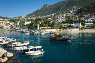 Kalkan, Türkiye - 12 Ekim 2019: Kalkan Marina 'da tekneler ve Türkiye' nin Akdeniz kıyısındaki tepelerde kasaba, Popüler turizm merkezi