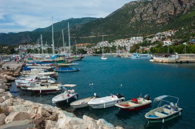Kas, Türkiye - 16 Ekim 2019: Kas Marina 'daki tekneler ve Türk Akdeniz kıyısındaki kayalık dağlar, Popüler turizm beldesi