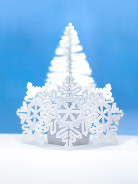 Op kerstboom en witte sneeuwvlokken op blauwe achtergrond — Stockfoto