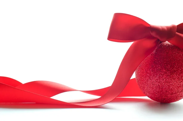 Bola roja de Navidad con gran arco rojo y cinta larga en el fondo blanco —  Fotos de Stock