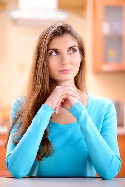 Retrato de una hermosa joven pensando en algo bueno en la cocina en casa — Foto de Stock