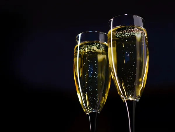 Twee glazen van champagne tegen donkere achtergrond — Stockfoto