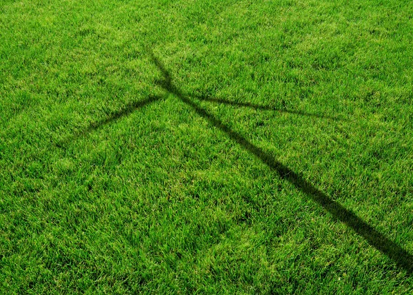 Wind generator turbine schaduw op het gras — Stockfoto