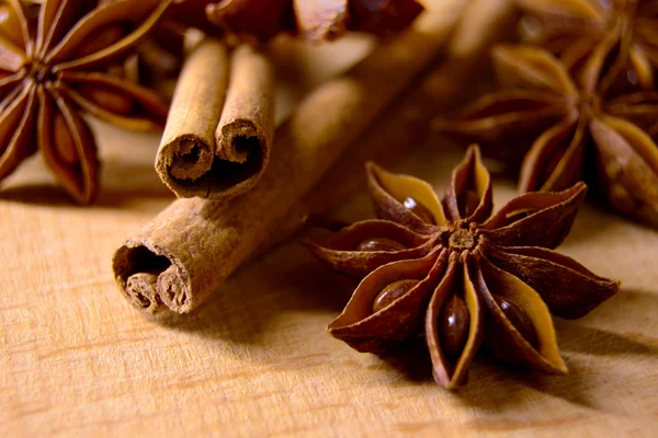 Anis de estrela e paus de canela na mesa de madeira — Fotografia de Stock