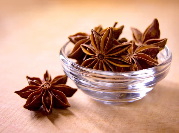 Estrella anís en el tazón de cristal en la mesa de madera — Foto de Stock