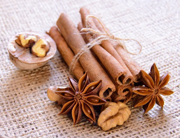 Nueces, anís estrellado y canela en el fondo de arpillera — Foto de Stock