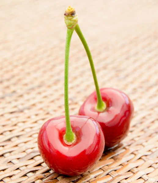 Duas cerejas vermelhas maduras doces em uma mesa de madeira — Fotografia de Stock