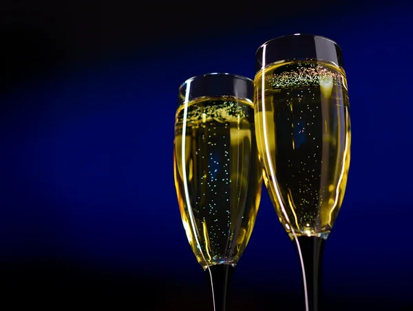 Twee glazen van champagne op donker blauwe achtergrond — Stockfoto