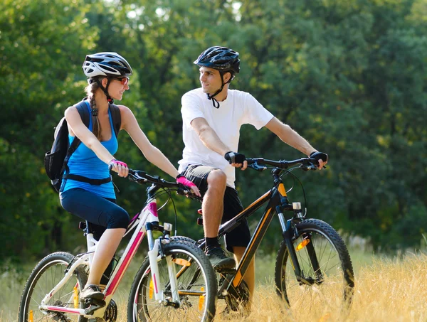 Молодые счастливые пары катаются на горных велосипедах на открытом воздухе — стоковое фото
