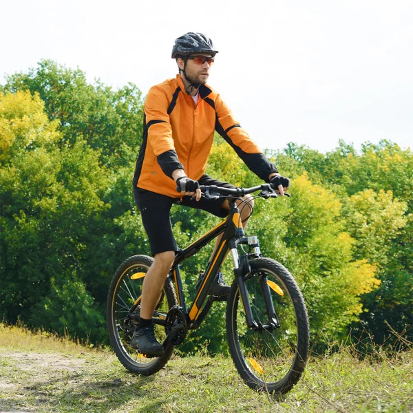 Ciclista montando a bicicleta na bela floresta de outono — Fotografia de Stock