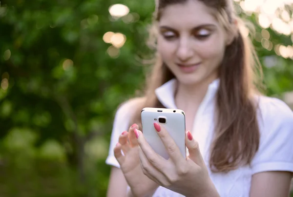 Молодая красивая женщина использует свой смартфон на открытом воздухе — стоковое фото