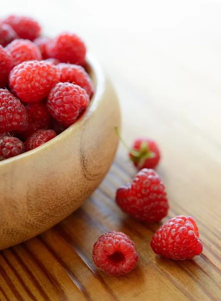 Rijp rood sappige frambozen in de houten kom op houten tafel — Stockfoto