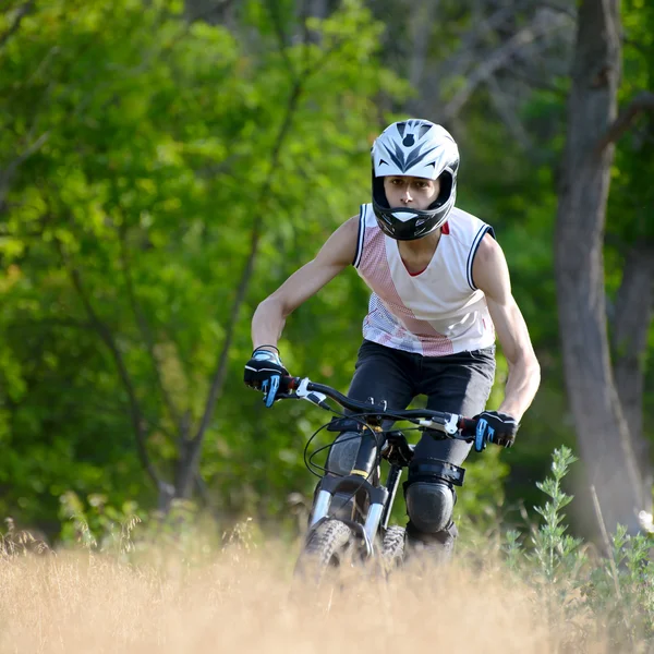 Ciclista montando la bicicleta en el sendero en el hermoso bosque — Foto de Stock