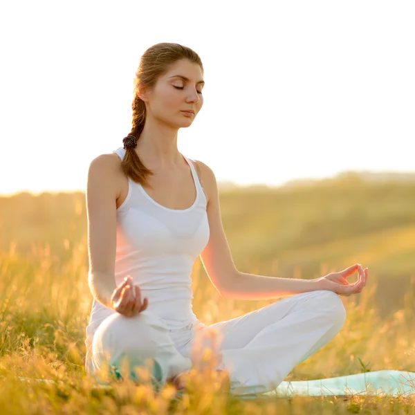 Genç güzel kadın güneşli çayır üzerinde yoga uygulamaları — Stok fotoğraf