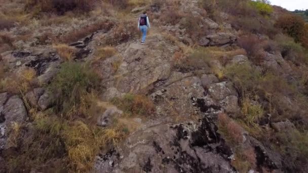 Mujer joven Senderismo en el sendero rocoso en las montañas de otoño. — Vídeo de stock