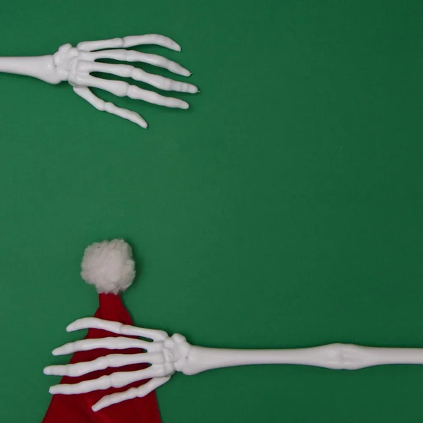 Csontváz Kezében Van Mikulás Kalapja Zöld Háttér Másolási Hellyel Minimális — Stock Fotó