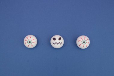 Ürkütücü gözler ve taşakların arasında mavi arkaplan üzerinde fotokopi alanı olan bir çizgi. Asgari düz bileşim.