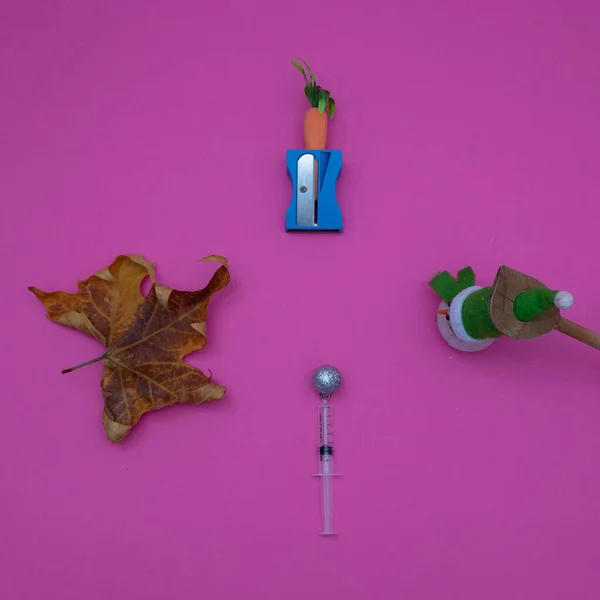 Sonbahar yaprağı, Snowman, Covid-19, pembe arka planda vitaminler. Asgari düz bileşim.