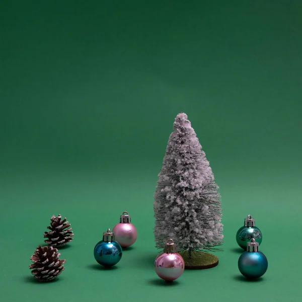 Noworoczne Drzewo Posypane Śniegiem Otoczone Noworocznymi Dekoracjami Szyszkami Zielonym Tle — Zdjęcie stockowe